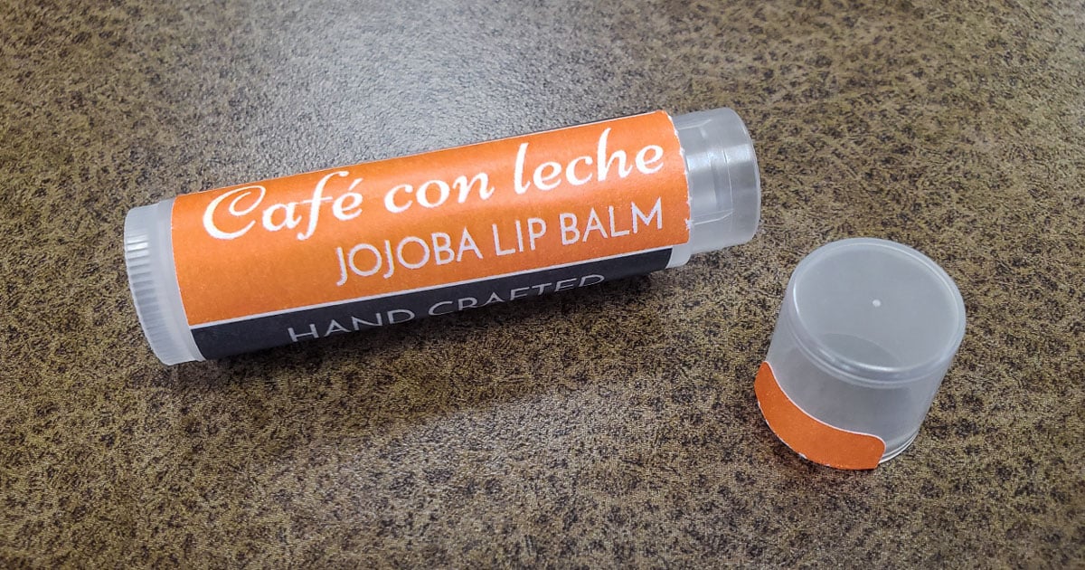 Photo of lip balm tube with a perforated safety seal tab applied and torn