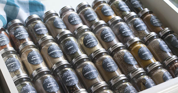 Chalkboard style farmhouse herb and spice circle labels on spice jars in a drawer