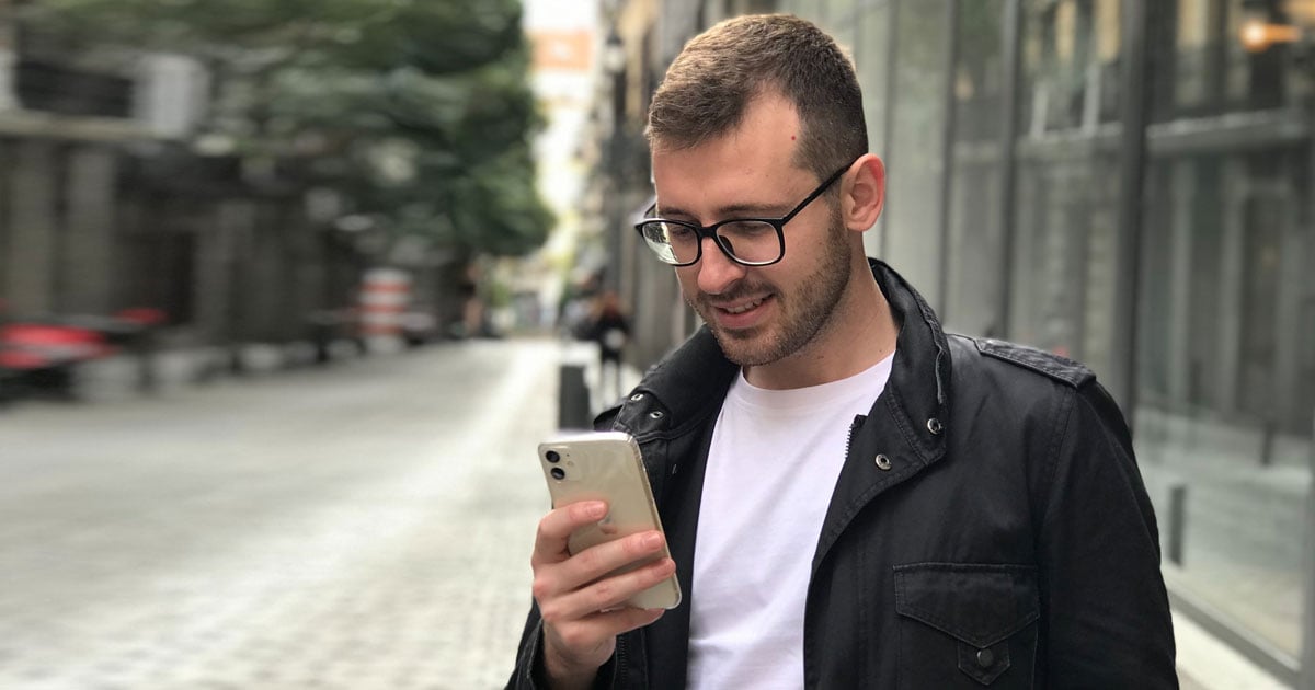 Man looking at his phone and smiling.