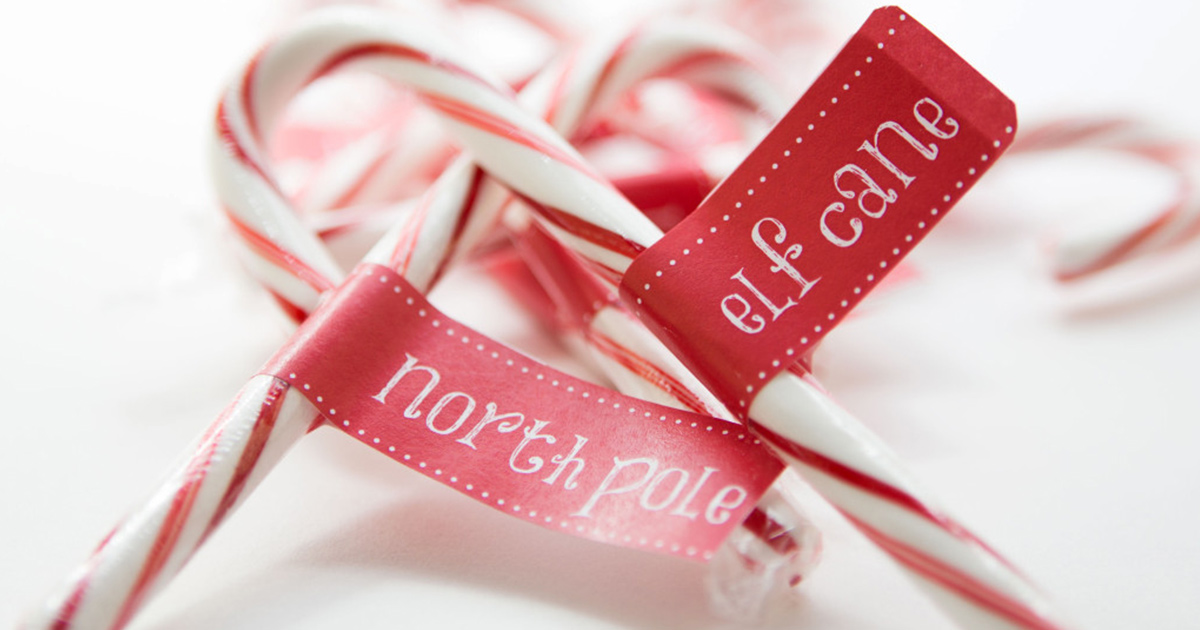 Christmas party decor with DIY candy cane printables: North Pole and Elf Cane labels wrapped around candy canes