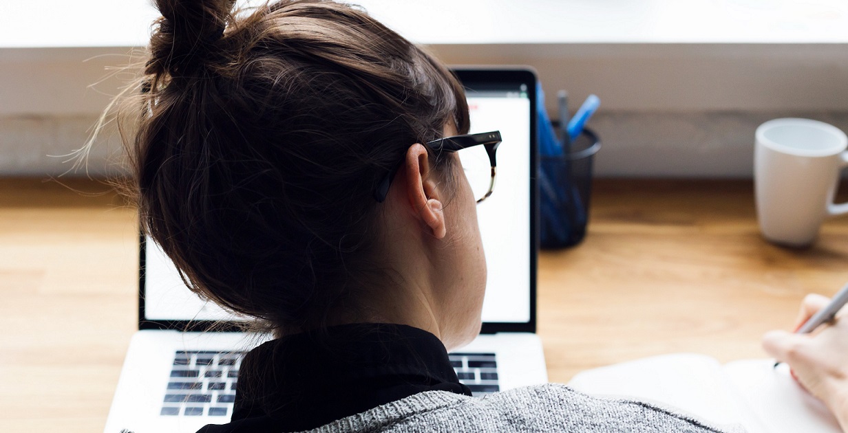 Woman at computer, taking notes