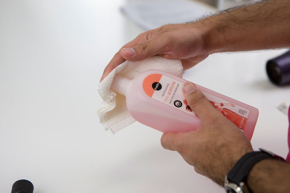 Soaking cloth with nail polish remover.