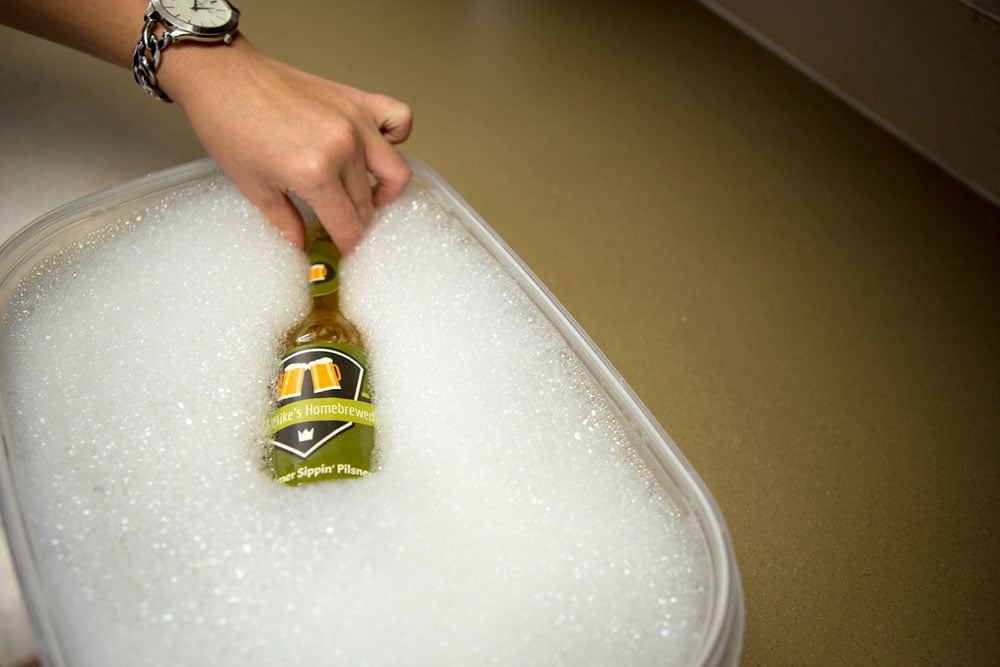 Placing the bottle in warm water and soap.